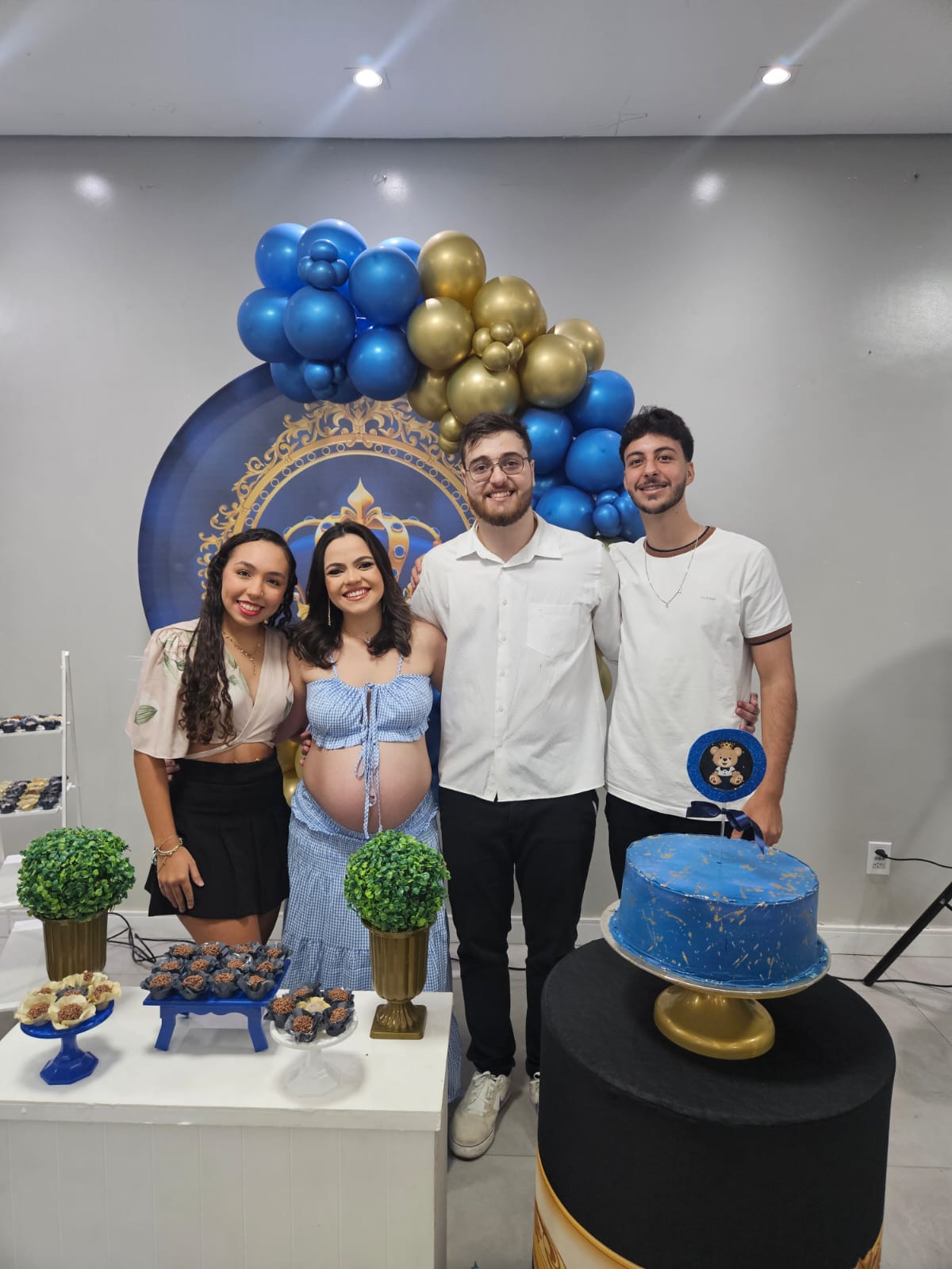 Duas mulheres e dois homens comemorando o chá de fraldas de um bebê